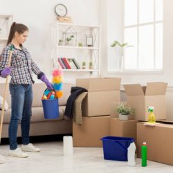 Young woman with cleaning equipment ready to clean new house after moving. Professional cleaning service concept, copy space